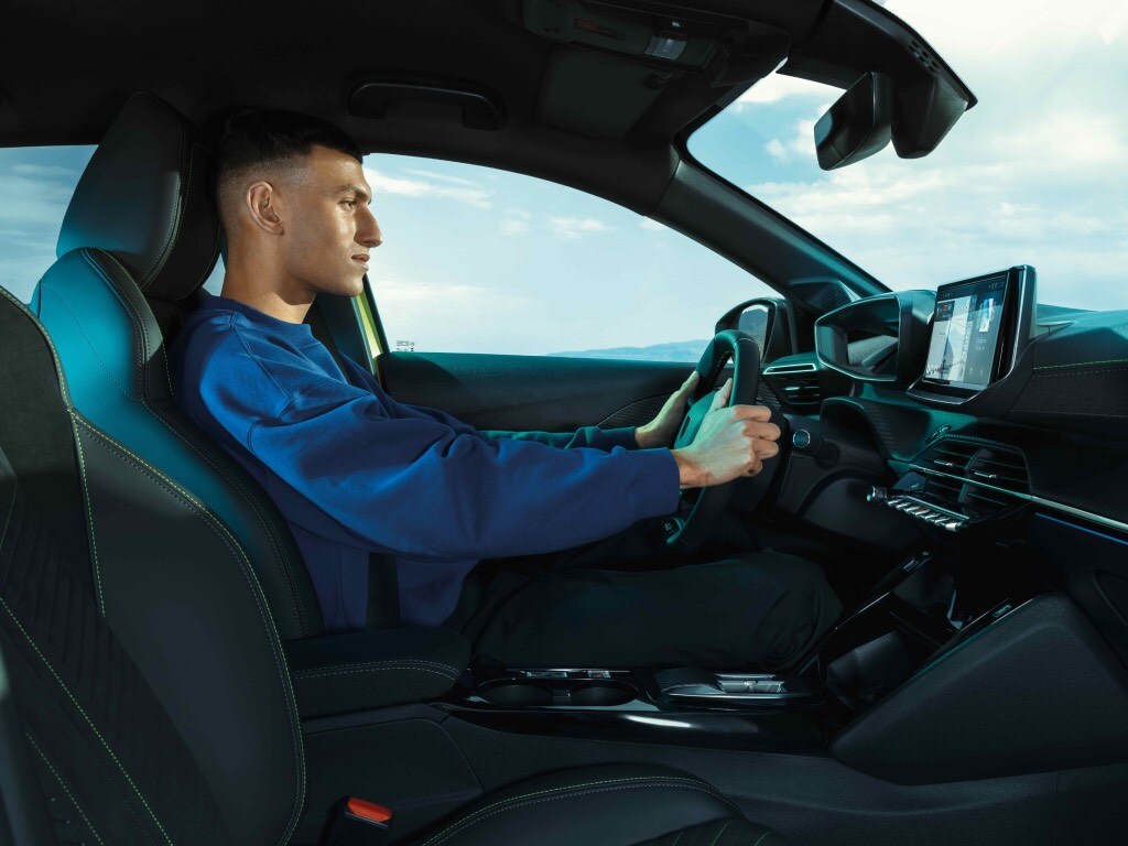 Mężczyzna prowadzący nowego PEUGEOT E-208