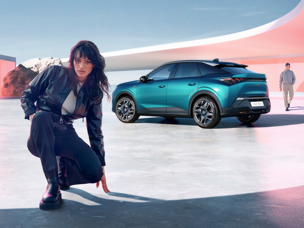 Kucająca kobieta obok nowego PEUGEOT 3008 Hybrid, widok z tyłu
